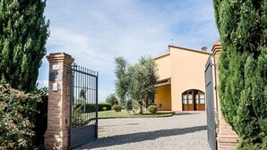 A gated entrance to a building with a paved driveway leading to a door. - Super panoramic, private pool, fast Wifi, Air cond, close to town - NO BILLS (Pisa)