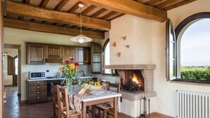 A rustic kitchen with wooden beams, a fireplace, and a dining area with a table set for two. - Super panoramic, private pool, fast Wifi, Air cond, close to town - NO BILLS (Pisa)