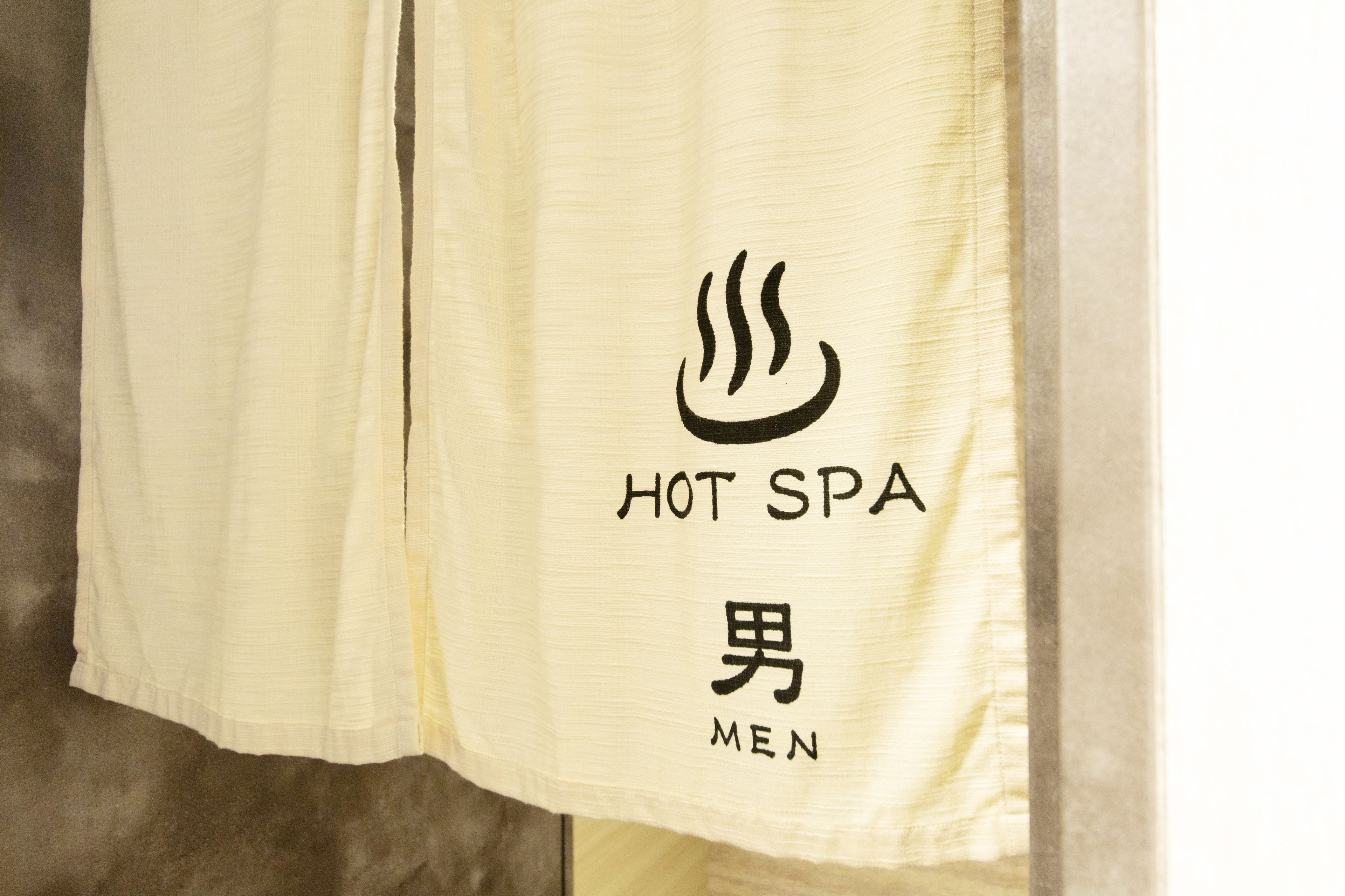 Une serviette sur laquelle sont écrits les mots « HOT SPA » et « MEN ».