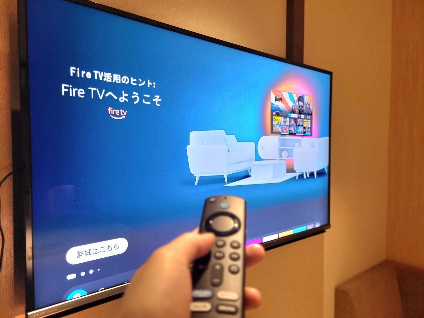Et fjernsyn med japansk tekst og en fjernbetjening i hånden.