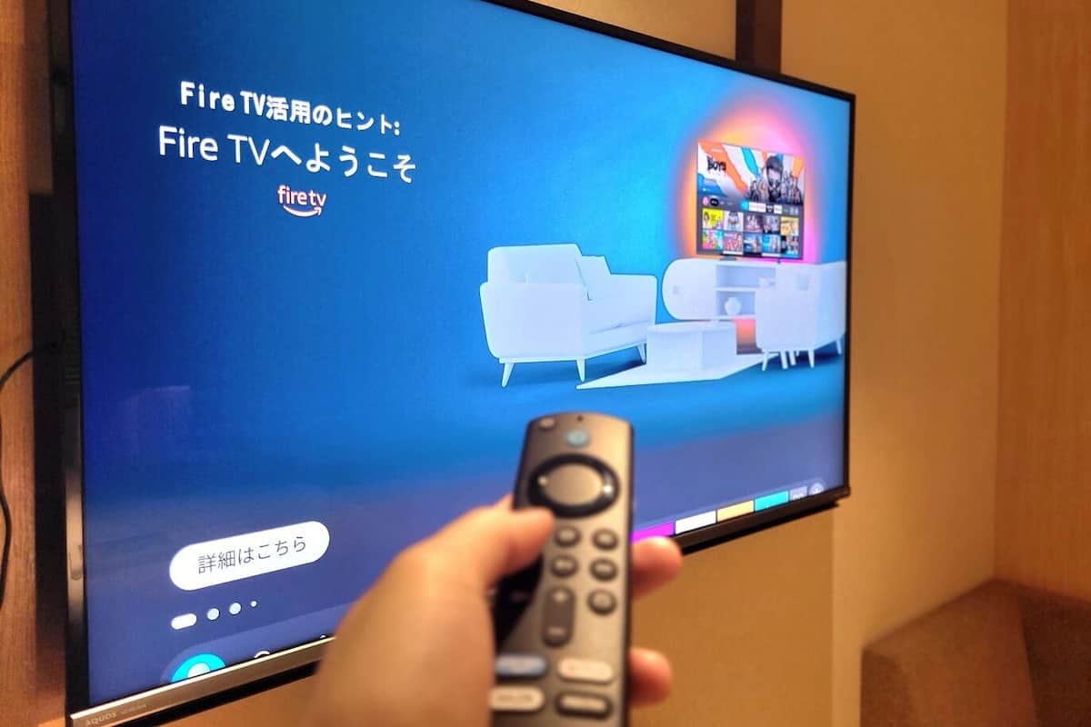 Una pantalla de televisión con texto en japonés y un control remoto en la mano.