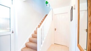 A staircase with beige carpet leading to a white door.