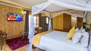 Een kamer met een bed, een televisie, een bureau en een stoel.