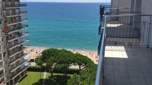 Ein Balkon mit Blick auf einen Strand und ein Schwimmbecken.