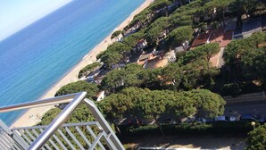 Blick aufs Meer vom Balkon mit Blick auf Strand, Bäume und Schwimmbad.