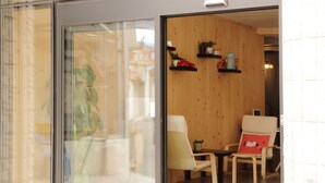 Une pièce avec un mur en bois, une chaise, une table et une petite étagère sur laquelle sont posés divers objets.