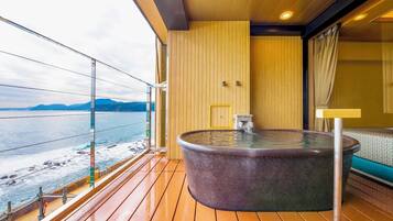 Un jacuzzi en un balcón con vistas al mar y a las montañas.