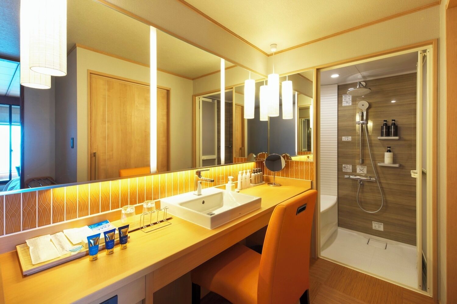 A modern bathroom with a double sink, a large mirror, and a shower area.