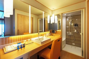 Un baño moderno con lavamanos doble, un espejo grande y una zona de ducha.