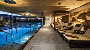 Una piscina cubierta, una piscina al aire libre, sombrillas, tumbonas