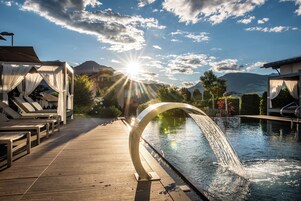 Una piscina techada, una piscina al aire libre, sombrillas