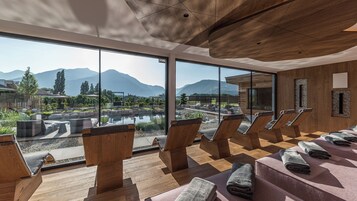 Una piscina techada, una piscina al aire libre, sombrillas