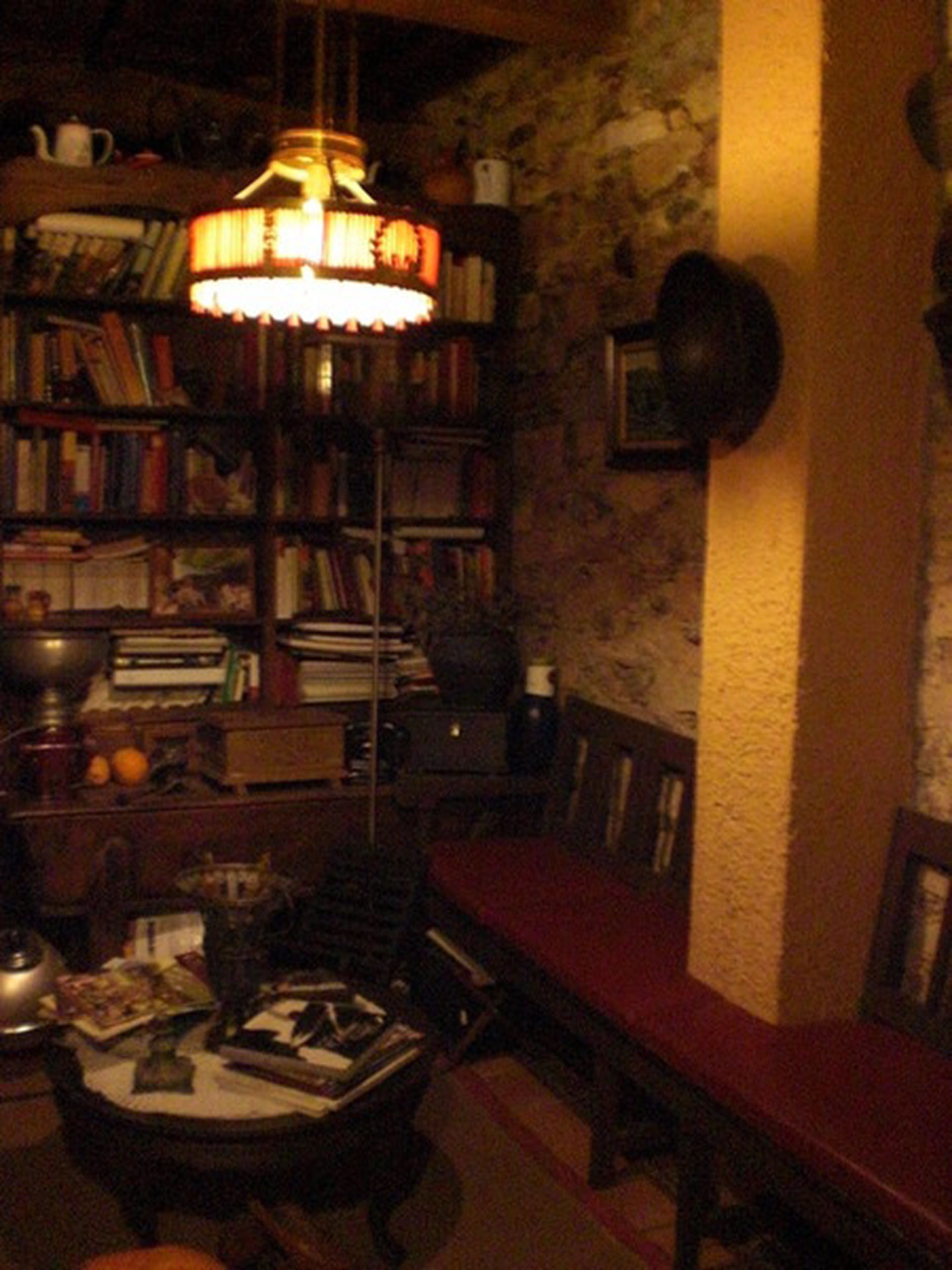A cozy reading nook with a bookshelf, a table, and a comfortable bench.