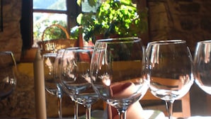 A table set with wine glasses, a potted plant, and a window with natural light. - Hotel Rural Genestoso (Cangas del Narcea)