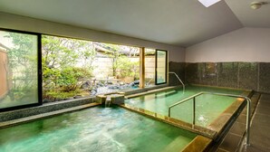 A traditional Japanese onsen with a view of a garden and a wooden structure outside. - Kagiya the annex of Senoumi (Minamiizu)