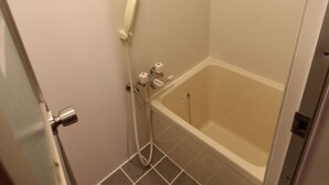 Un baño pequeño con bañera, ducha e inodoro.