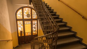 A staircase with ornate iron railings and a stained glass door at the top. - Riverside Apartment With A Balcony (Prague)