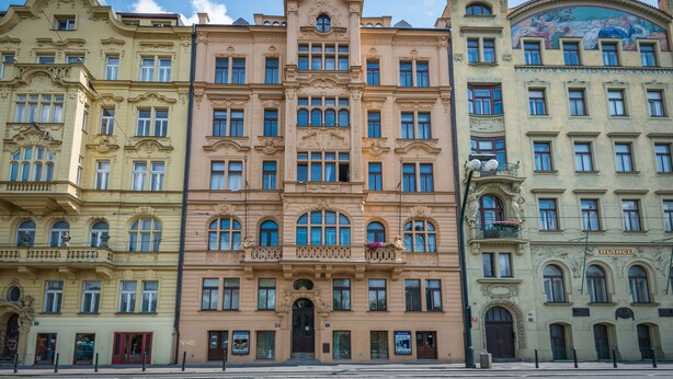 A row of multi-story buildings with classical architecture, featuring ornate facades and large windows. - Riverside Apartment With A Balcony (Prague)