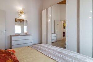 A bedroom with a bed, dresser, mirror, and wardrobe. - Cimadolmo Prosecco and History (Cimadolmo)