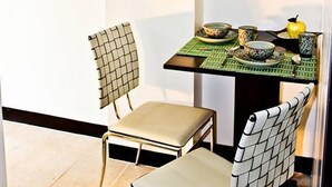 Ein kleiner Essbereich mit Tisch, zwei Stühlen und einem Spiegel an der Wand.