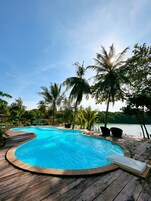 Una piscina al aire libre, sillones reclinables de piscina