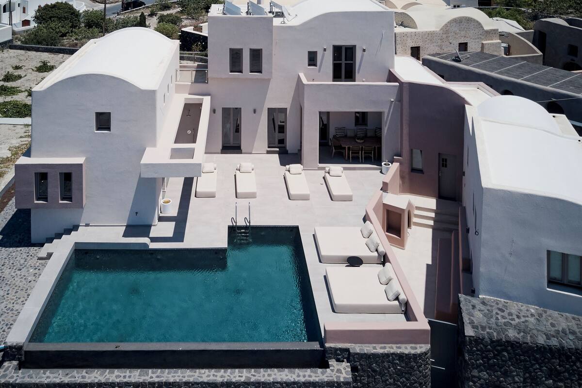 A modern building with a swimming pool, multiple lounge areas, and a covered outdoor seating area.