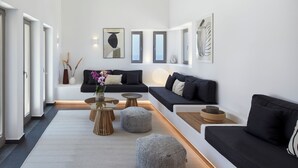 A modern living room with a sofa set, ottomans, and a coffee table.