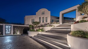 A modern hotel entrance with a stone-tiled pathway leading to a set of stairs.