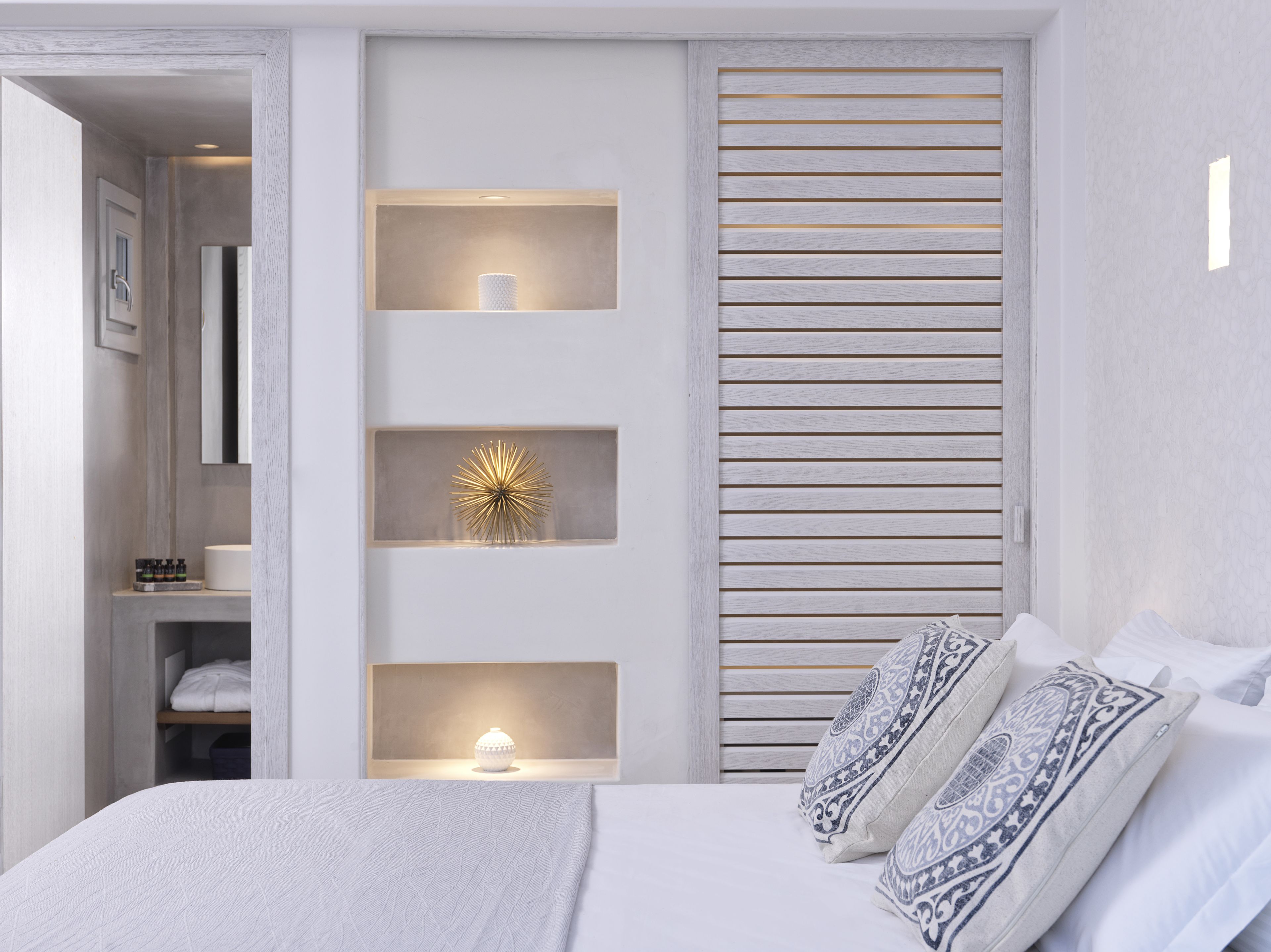 Ein modernes Schlafzimmer mit einem Bett, dekorativen Wandschränken und einer Schiebetür.