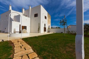 Un edificio moderno y blanco, con un camino de piedra que conduce a la entrada.
