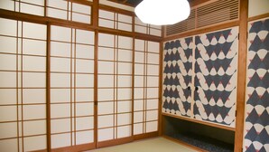 A traditional Japanese room with tatami flooring, shoji screens, and a patterned sliding door. - Chika Seiryu (Kyoto)