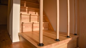 A wooden staircase with a modern design, featuring a straight flight of stairs and a handrail on the right side. - Chika Seiryu (Kyoto)