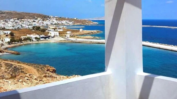 Un balcon avec vue sur une ville côtière et la mer.