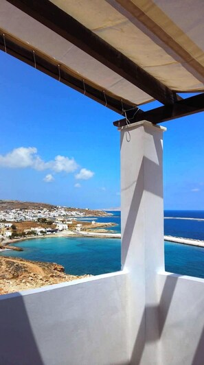 Un balcon avec vue sur une ville côtière et la mer.
