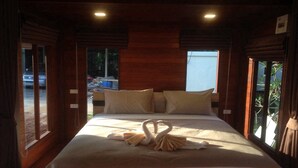A hotel room with a large bed, wooden walls, and a view of the outside. - Check In & Chill Out Laem Sok Pier (Trat)