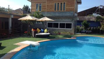 Una piscina con una casa de madera al fondo.