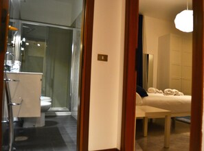 A modern bathroom with a glass shower enclosure, a toilet, and a sink.