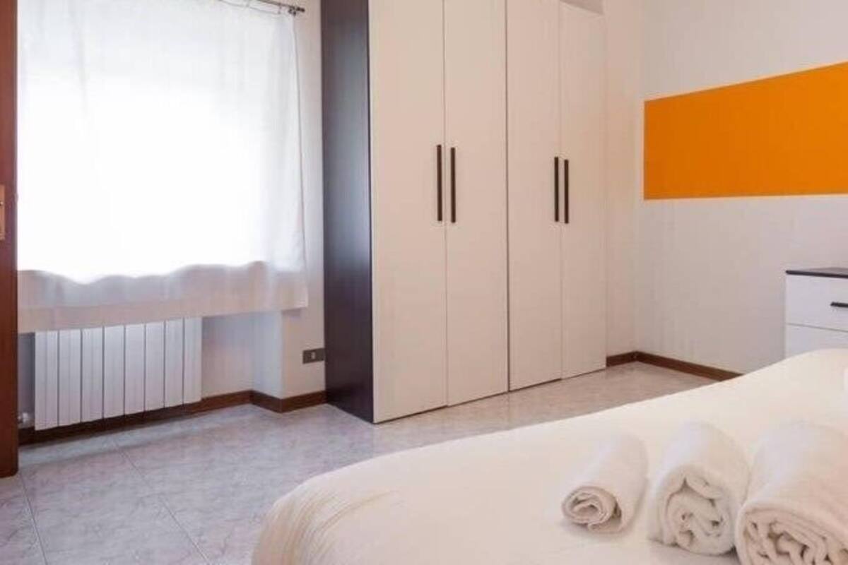 Une chambre d’hôtel avec un lit, une armoire et une fenêtre avec des rideaux.