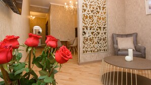 A room with a round table, a sofa, and a decorative partition. - Dat Exx Apartments (Tbilisi)