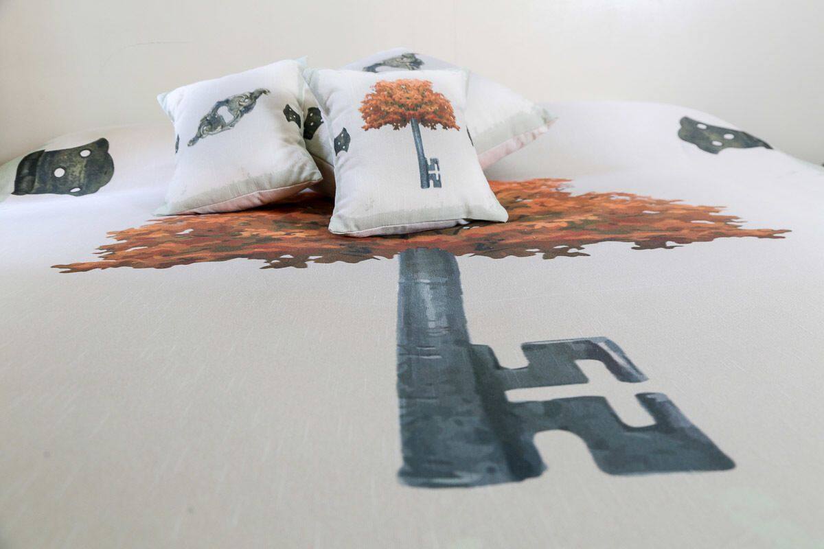 Ein Bett mit einem kissenförmigen Schlüssel und einem kissenförmigen Baum.