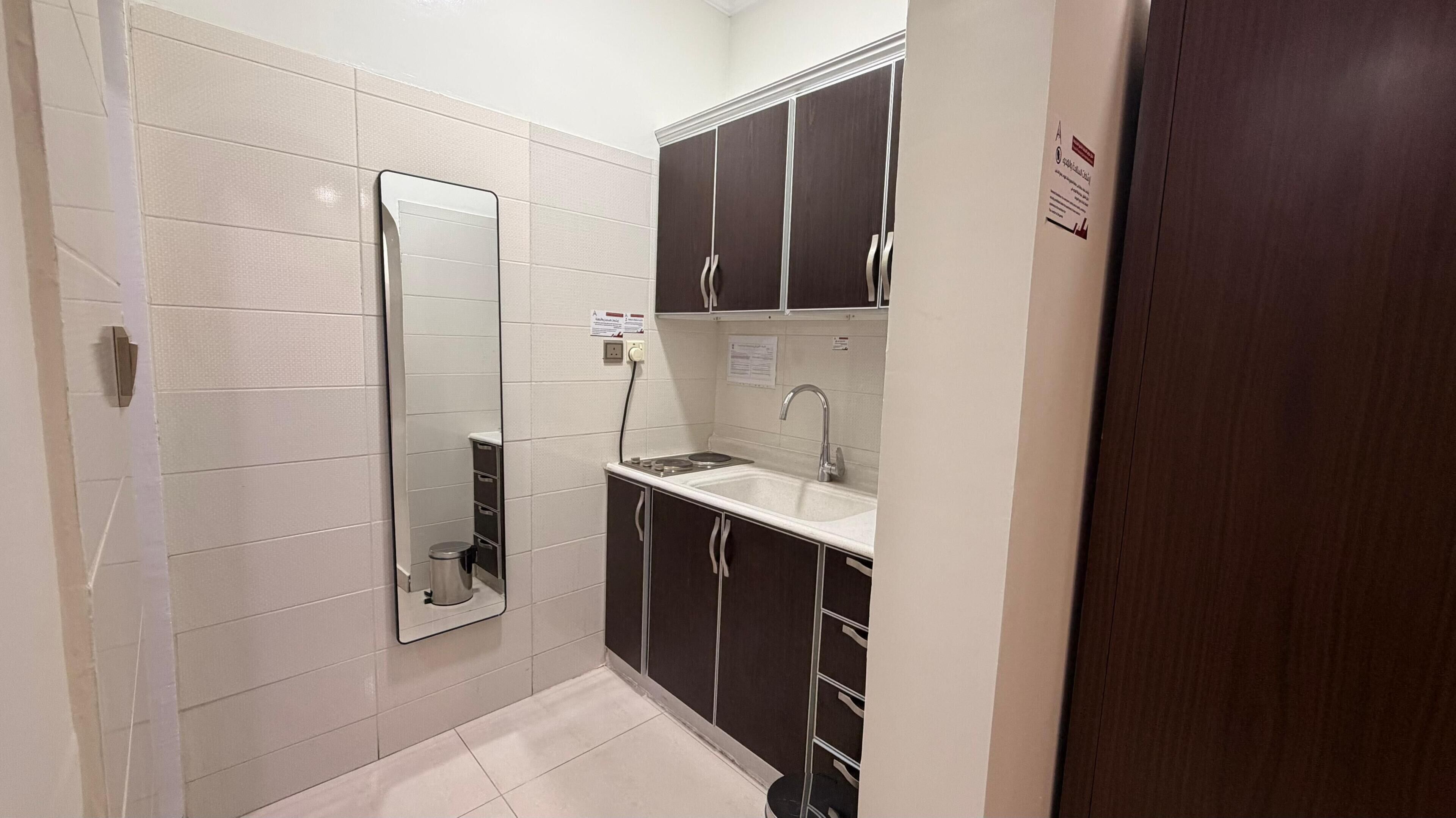 A compact bathroom with a mirror, sink, and cabinets.