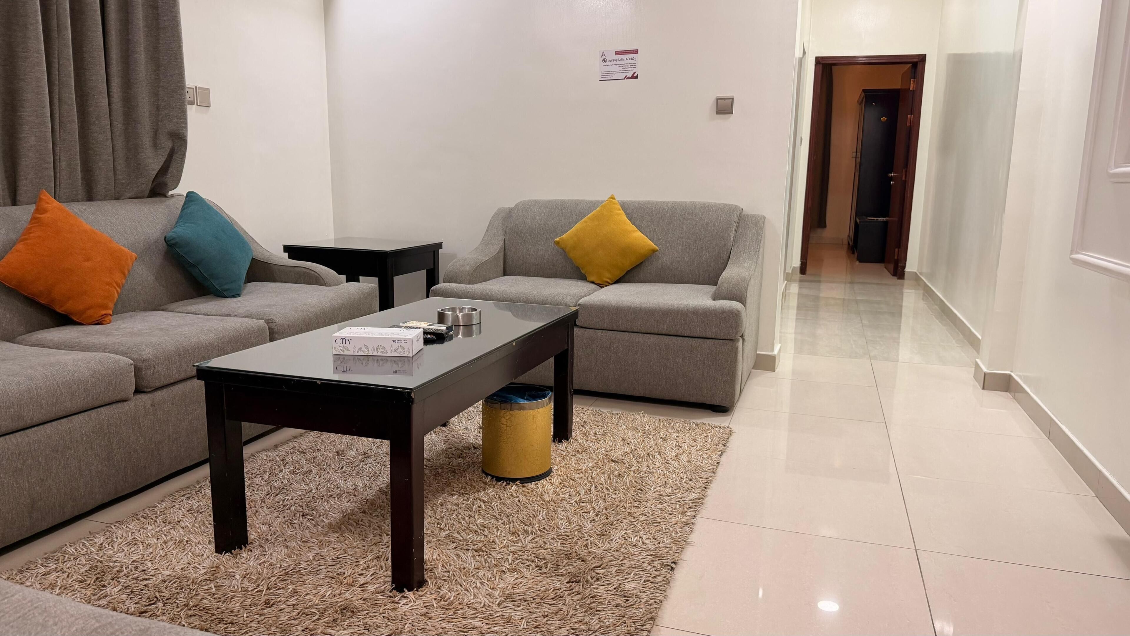 A modern living room with two grey sofas, a coffee table, and a small side table.