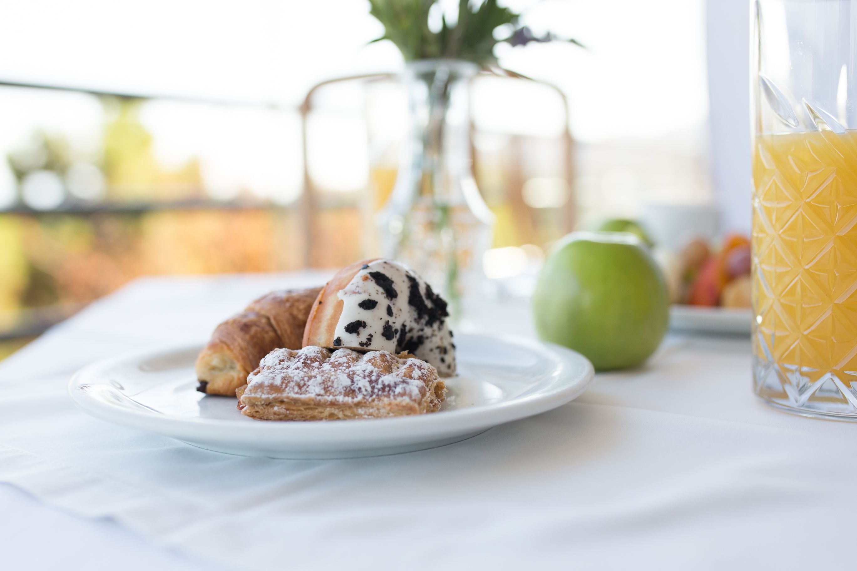 A breakfast setting with pastries and a glass of orange juice on a table.