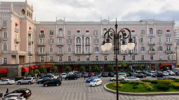 Un hotel grande con varios pisos, un patio central y un estacionamiento lleno de coches.