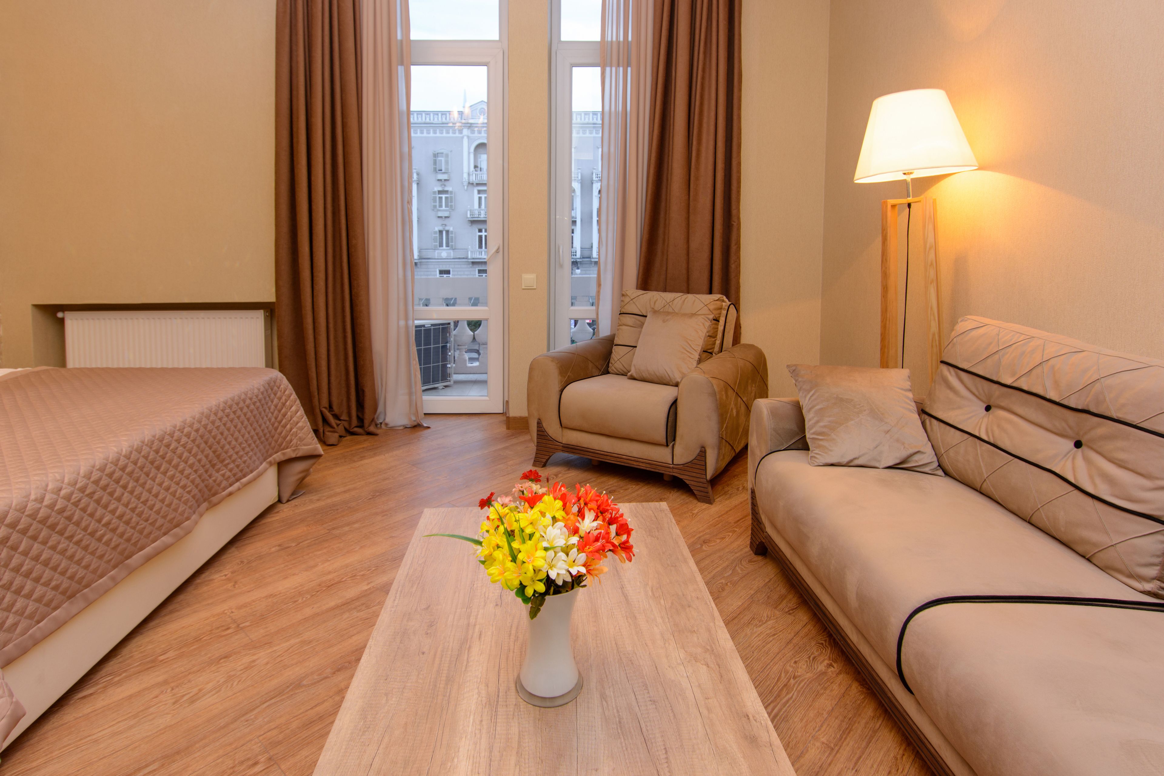 Ein Hotelzimmer mit einem Bett, einer Couch, einem Sessel und einer Lampe.