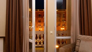 Una habitación con sofá, cortinas y vistas a un edificio iluminado.