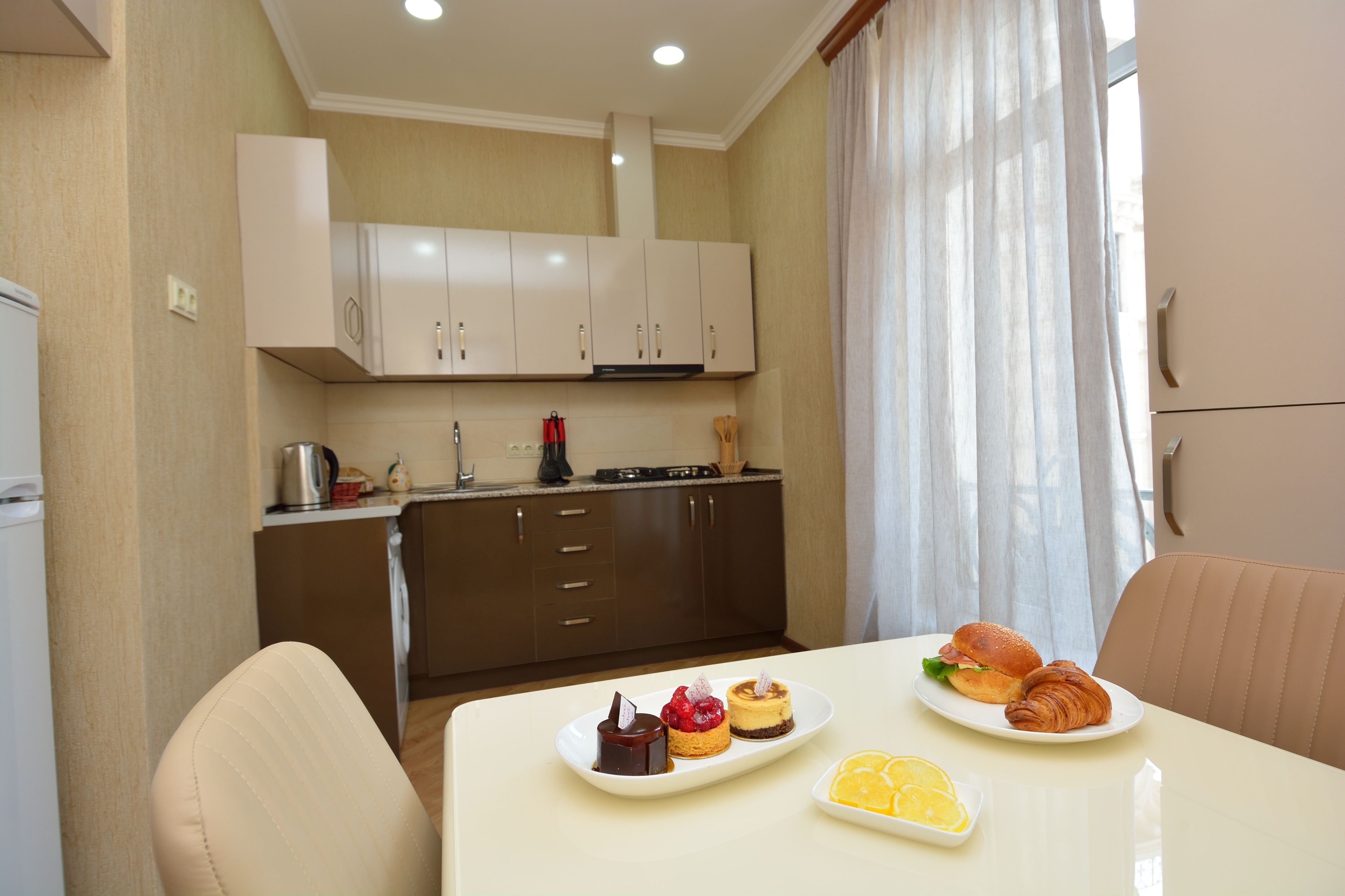 A compact kitchen with modern appliances and a dining area with a table set for breakfast.