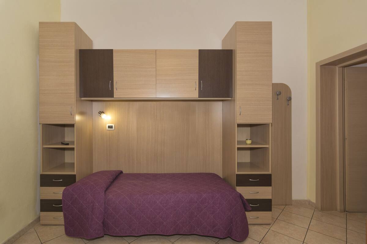 Ein Schlafzimmer mit Bett, Einbauschränken und Regalen.