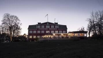 A large, two-story building with a red facade and a sign reading "Eurinds Vårshus."