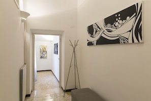 Ein Flur mit einer Bank, einer Stehlampe und einem Bild an der Wand.